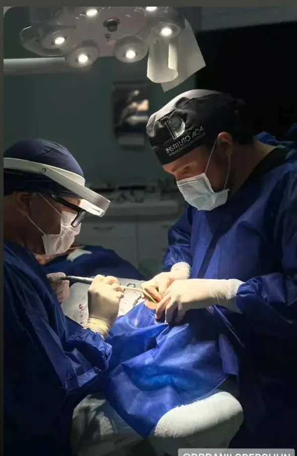Dr. Radamés e auxiliar durante uma cirurgia de implante